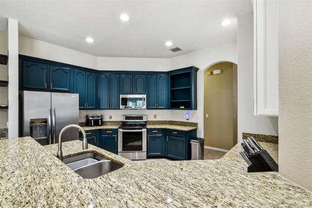 2009 Raven Manor Dr, Dover, FL 33527 - kitchen with stainless steel appliances, light stone countertops, arched walkways, blue cabinets, and light tile patterned flooring