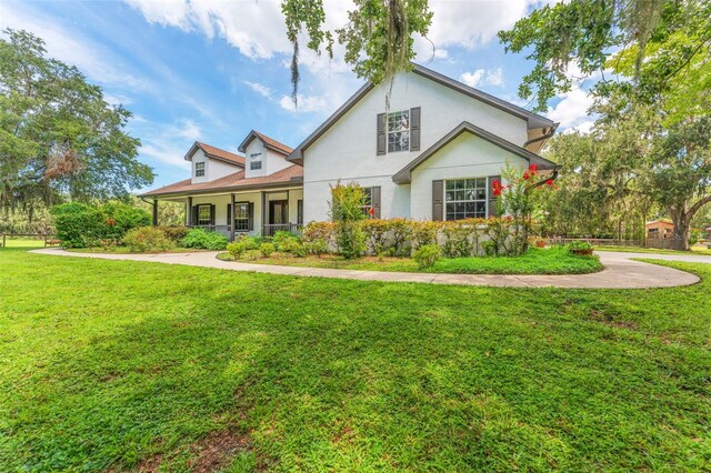 2702 Rogers Ranch Rd, Lithia, FL 33547 - view of front facade with a front yard, a porch, and stucco siding
