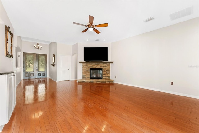 2702 Rogers Ranch Rd, Lithia, FL 33547 - unfurnished living room featuring a chandelier, light wood-style flooring, a ceiling fan, a fireplace, and recessed lighting