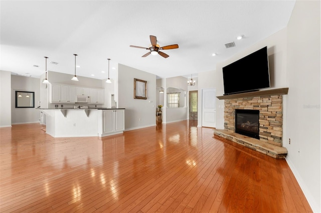 2702 Rogers Ranch Rd, Lithia, FL 33547 - unfurnished living room with ceiling fan, a fireplace, light wood-type flooring, a chandelier, and recessed lighting