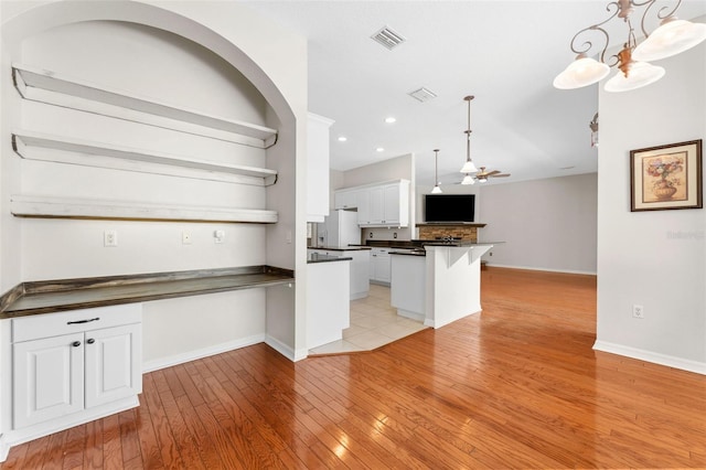 2702 Rogers Ranch Rd, Lithia, FL 33547 - kitchen featuring dark countertops, open shelves, open floor plan, light wood-style flooring, and white cabinetry