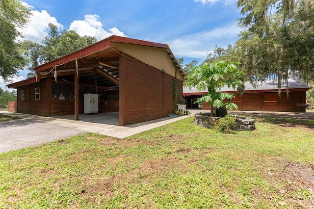 2702 Rogers Ranch Rd, Lithia, FL 33547 - view of side of property featuring asphalt driveway, a yard, and an outbuilding