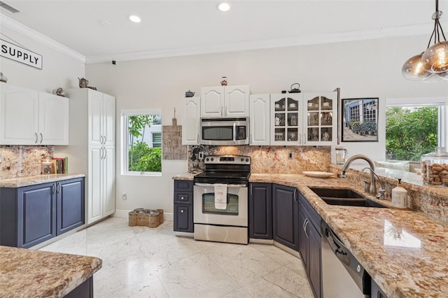 17001 NW 20th St, Pembroke Pines, FL 33028 - kitchen featuring stainless steel appliances, plenty of natural light, white cabinetry, ornamental molding, and tasteful backsplash