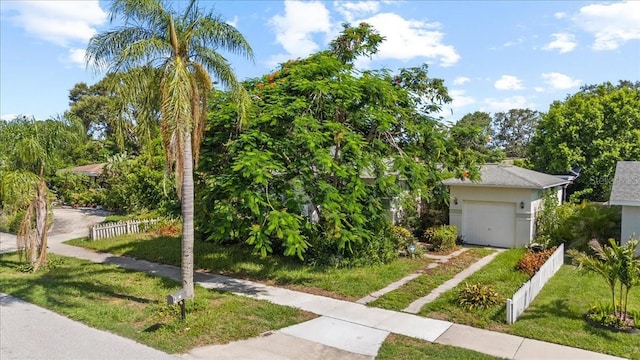 1222 Palm St, Clearwater, FL 33755 - view of property hidden behind natural elements featuring driveway, a garage, and stucco siding