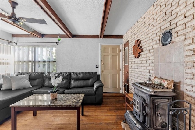 1222 Palm St, Clearwater, FL 33755 - living area with a wood stove, beamed ceiling, wood finished floors, a textured ceiling, and ceiling fan