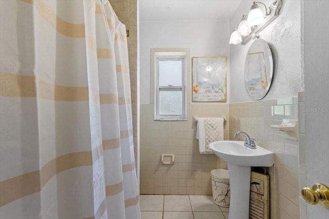 1222 Palm St, Clearwater, FL 33755 - bathroom featuring tile walls, tile patterned floors, a shower with curtain, and a wainscoted wall