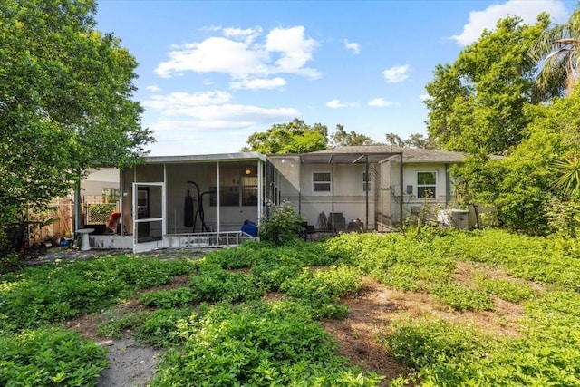 1222 Palm St, Clearwater, FL 33755 - back of property featuring a sunroom, stucco siding, and a lanai