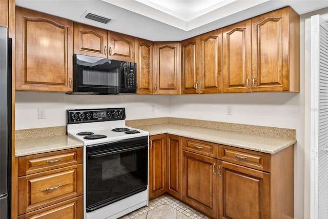 524 Garrard Dr, Temple Terrace, FL 33617 - kitchen with white electric range oven, black microwave, brown cabinetry, and light countertops