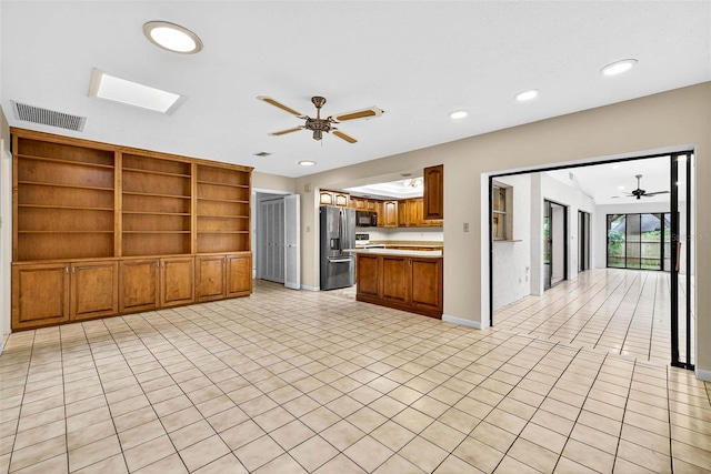 524 Garrard Dr, Temple Terrace, FL 33617 - kitchen featuring ceiling fan, stainless steel refrigerator with ice dispenser, brown cabinets, light countertops, and open floor plan