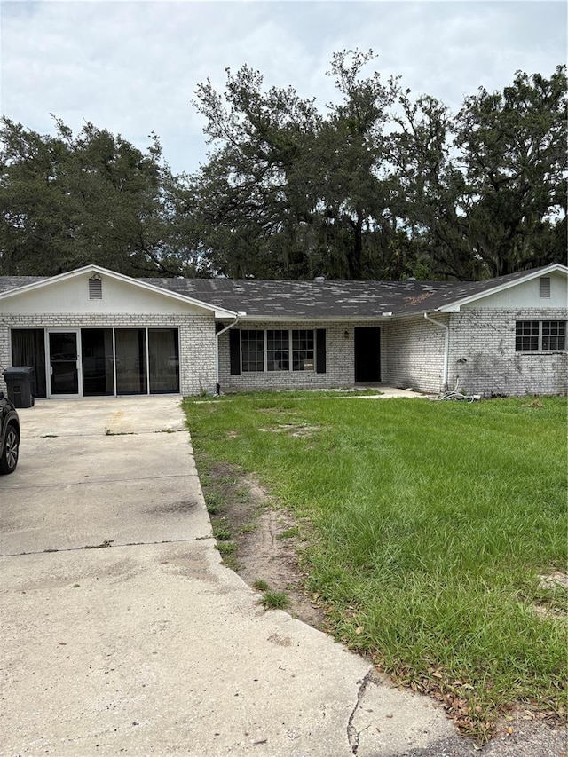 1214 Mitchell St, Brandon, FL 33511 - view of front of home featuring brick siding, a front yard, and driveway