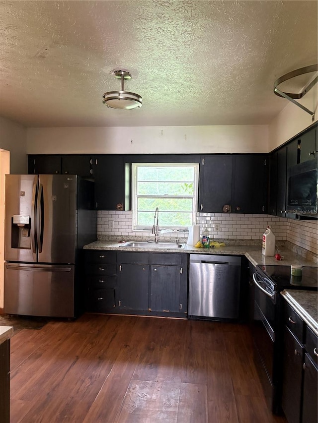 1214 Mitchell St, Brandon, FL 33511 - kitchen with black appliances, a textured ceiling, dark wood finished floors, and dark cabinetry