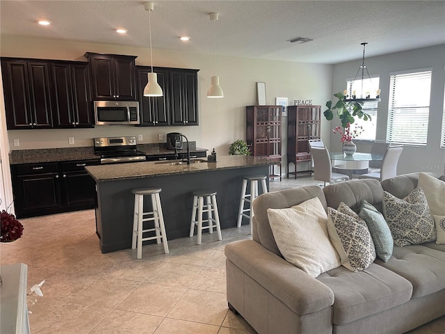 1596 Ludington Ave, Wesley Chapel, FL 33543 - kitchen featuring stainless steel appliances, open floor plan, a breakfast bar area, a chandelier, and recessed lighting