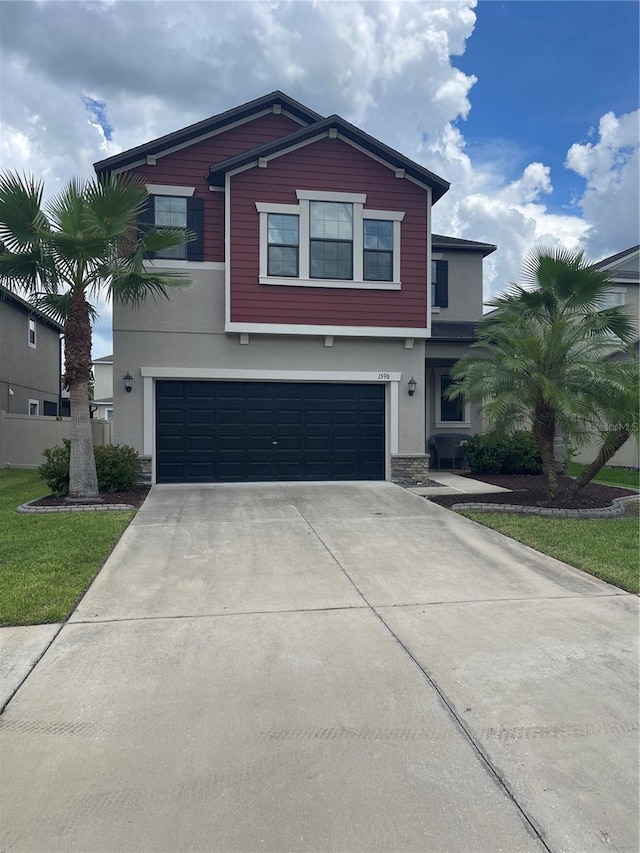 1596 Ludington Ave, Wesley Chapel, FL 33543 - view of front of house with stucco siding, stone siding, a garage, and driveway
