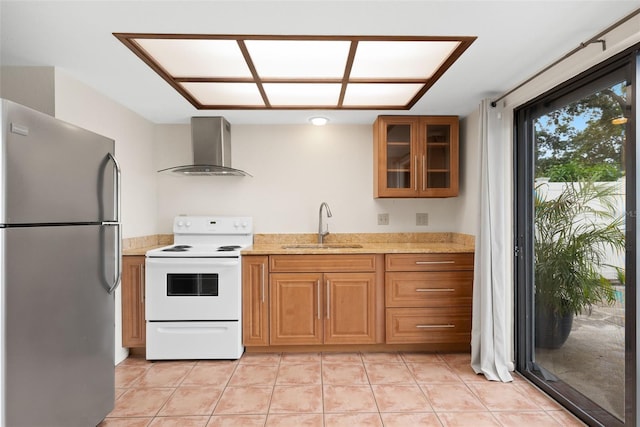 5217 29th Ave S, Gulfport, FL 33707 - kitchen featuring freestanding refrigerator, wall chimney exhaust hood, electric range, glass insert cabinets, and light tile patterned floors