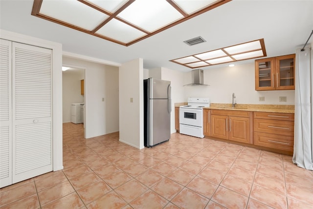5217 29th Ave S, Gulfport, FL 33707 - kitchen with white range with electric stovetop, freestanding refrigerator, wall chimney exhaust hood, washer / clothes dryer, and light countertops