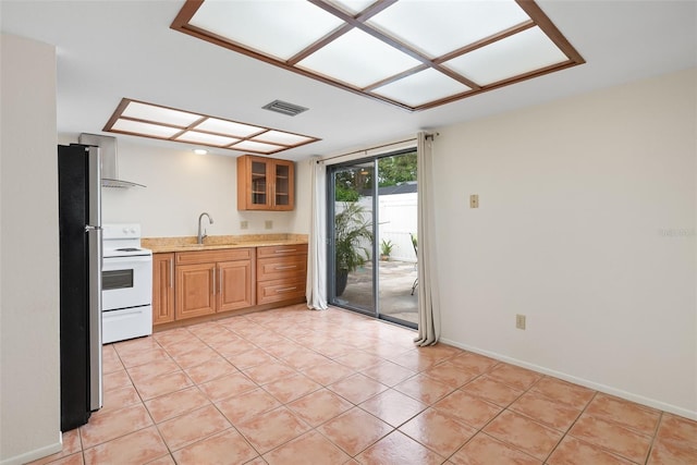 5217 29th Ave S, Gulfport, FL 33707 - kitchen featuring white electric range oven, freestanding refrigerator, light countertops, wall chimney range hood, and light tile patterned flooring