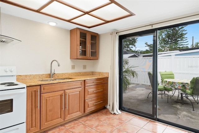 5217 29th Ave S, Gulfport, FL 33707 - kitchen with white electric stove, plenty of natural light, glass insert cabinets, and light tile patterned flooring