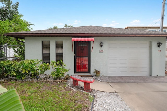 5217 29th Ave S, Gulfport, FL 33707 - view of front of house featuring stucco siding, driveway, roof with shingles, and a garage