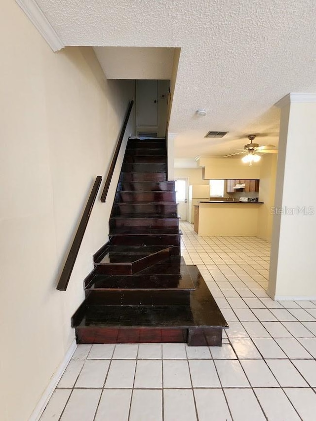 6620 121st Ave Unit 1, Largo, FL 33773 - stairway featuring a textured ceiling, a ceiling fan, tile patterned floors, and crown molding