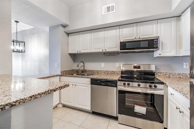 501 S Moody Ave Unit 1134, Tampa, FL 33609 - kitchen featuring stainless steel appliances, white cabinetry, a chandelier, and light tile patterned flooring