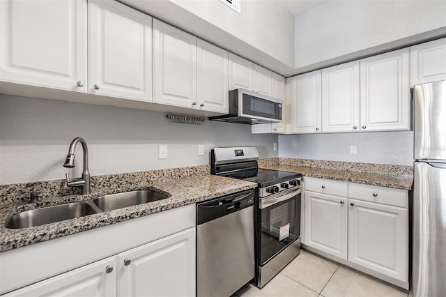 501 S Moody Ave Unit 1134, Tampa, FL 33609 - kitchen with stainless steel appliances, white cabinets, light tile patterned flooring, and light stone counters