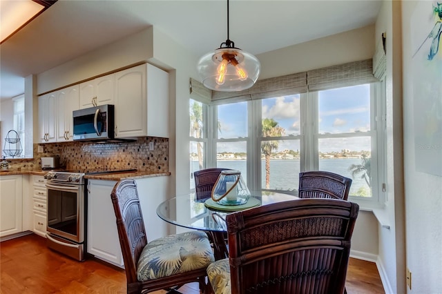 6105 Bahia Del Mar Cir Unit 388, Saint Petersburg, FL 33715 - dining room with a water view, plenty of natural light, and wood finished floors
