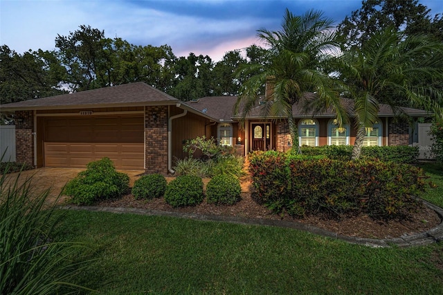 11279 Oakridge Trl, Seminole, FL 33772 - ranch-style house featuring an attached garage, brick siding, a front lawn, and driveway