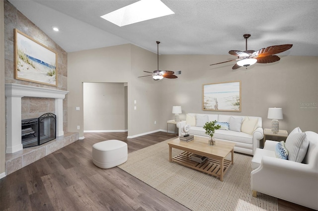 11279 Oakridge Trl, Seminole, FL 33772 - living area featuring lofted ceiling, wood finished floors, a skylight, a tiled fireplace, and a ceiling fan