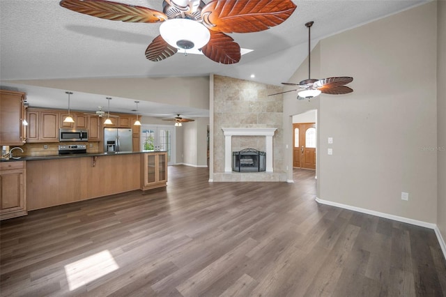 11279 Oakridge Trl, Seminole, FL 33772 - unfurnished living room featuring a ceiling fan, a tile fireplace, dark wood-style floors, and high vaulted ceiling