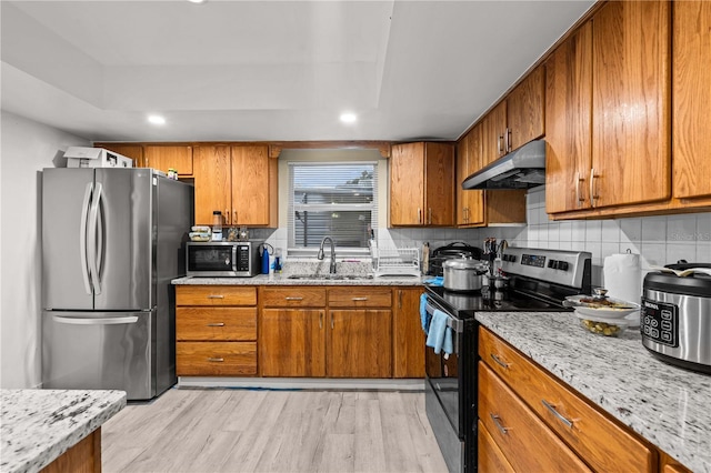 523 Northride Trl, Lakeland, FL 33813 - kitchen featuring stainless steel appliances, under cabinet range hood, brown cabinets, light wood-style floors, and recessed lighting