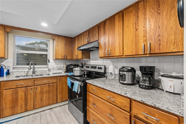 523 Northride Trl, Lakeland, FL 33813 - kitchen featuring stainless steel range with electric cooktop, brown cabinets, under cabinet range hood, and backsplash