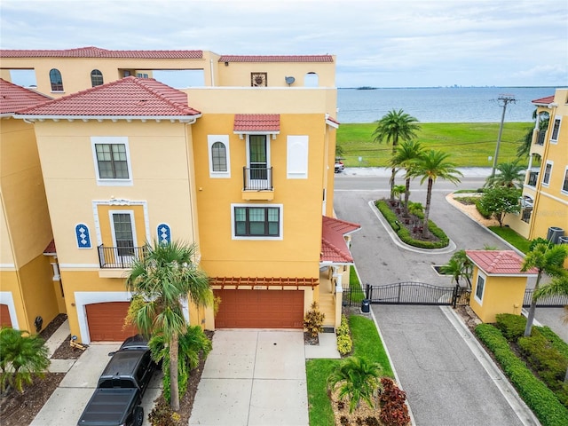 6412 Mayra Shores Ln, Apollo Beach, FL 33572 - view of property featuring a gate, stucco siding, concrete driveway, a garage, and a water view
