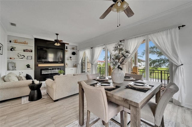 6412 Mayra Shores Ln, Apollo Beach, FL 33572 - dining space with ceiling fan, ornamental molding, and a large fireplace