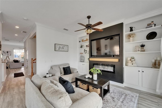 6412 Mayra Shores Ln, Apollo Beach, FL 33572 - living room with a glass covered fireplace, ornamental molding, a ceiling fan, built in features, and recessed lighting