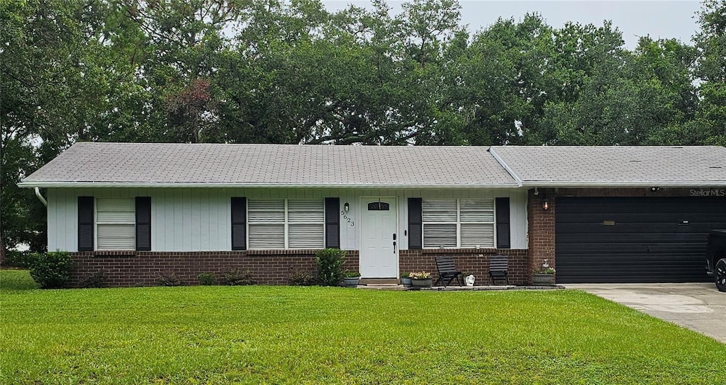 5623 Southernview Dr, Zephyrhills, FL 33541 - ranch-style home with brick siding, a garage, a front lawn, and driveway