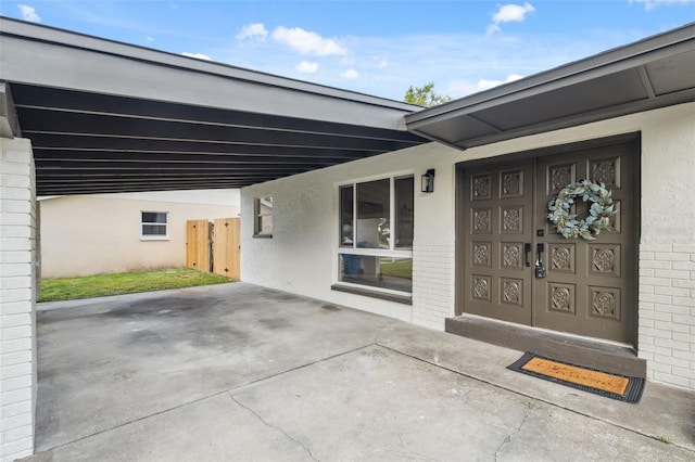 8256 Lark St, Seminole, FL 33777 - property entrance with a carport, stucco siding, and brick siding