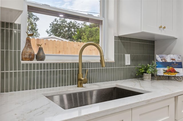 8256 Lark St, Seminole, FL 33777 - kitchen view of tasteful backsplash, white cabinets, and light stone countertops