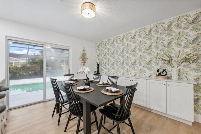 8256 Lark St, Seminole, FL 33777 - dining area with wallpapered walls, light wood-type flooring, wainscoting, and a textured ceiling