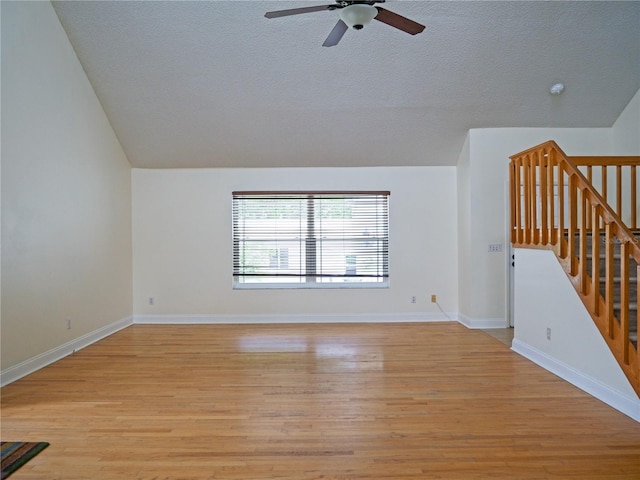 8759 Orient Way NE, Saint Petersburg, FL 33702 - unfurnished living room with a ceiling fan, a textured ceiling, light wood-style flooring, stairway, and vaulted ceiling