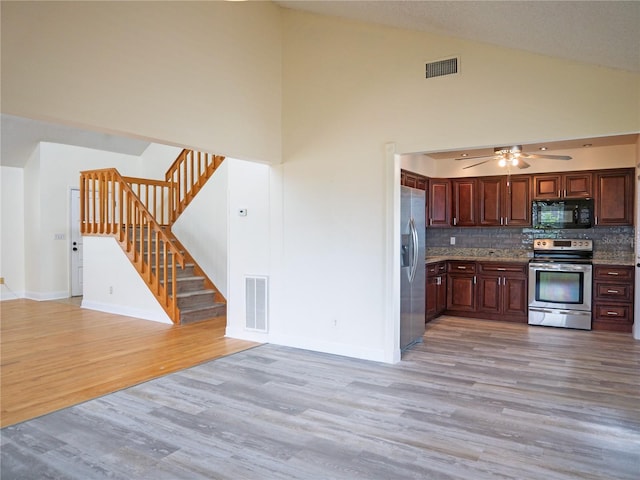 8759 Orient Way NE, Saint Petersburg, FL 33702 - kitchen featuring appliances with stainless steel finishes, light wood-type flooring, tasteful backsplash, a ceiling fan, and high vaulted ceiling