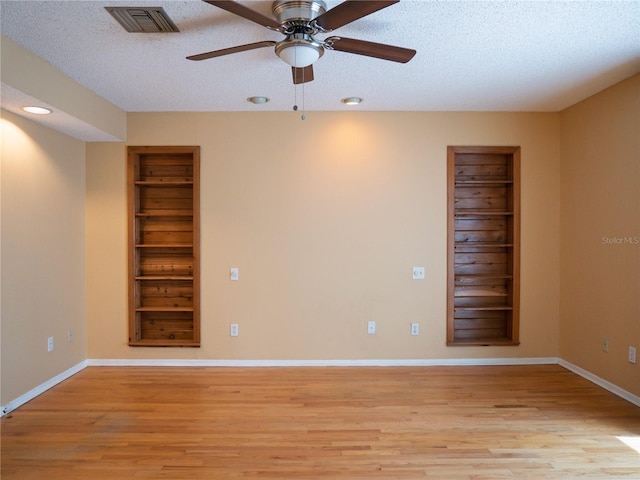8759 Orient Way NE, Saint Petersburg, FL 33702 - spare room with light wood-style flooring, ceiling fan, built in shelves, a textured ceiling, and recessed lighting