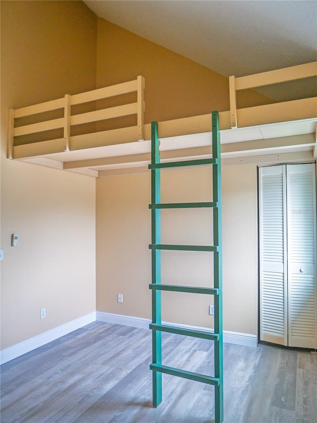 8759 Orient Way NE, Saint Petersburg, FL 33702 - unfurnished bedroom featuring wood finished floors, vaulted ceiling, and a closet