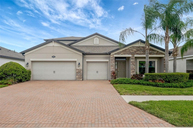 18125 Roseate Dr, Lutz, FL 33558 - view of front of house featuring decorative driveway, stone siding, stucco siding, and a garage