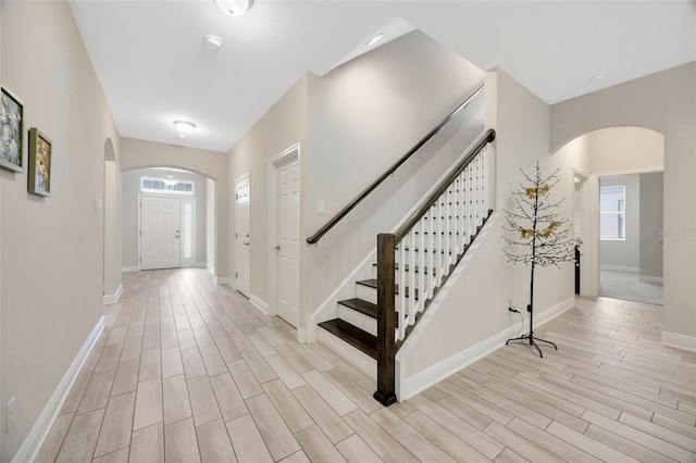 18125 Roseate Dr, Lutz, FL 33558 - foyer entrance featuring arched walkways, light wood finished floors, and stairs
