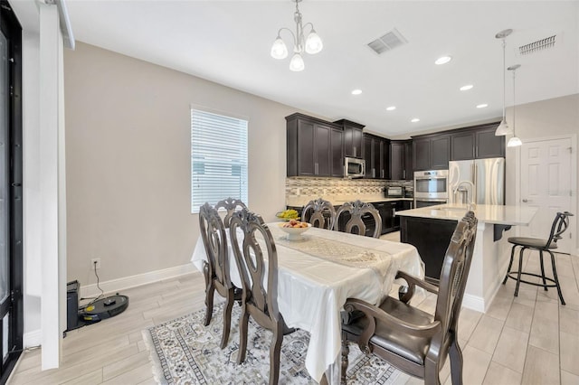 18125 Roseate Dr, Lutz, FL 33558 - dining area featuring light wood-style flooring, a chandelier, and recessed lighting