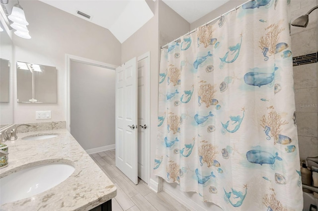 18125 Roseate Dr, Lutz, FL 33558 - bathroom featuring double vanity, shower / bath combination with curtain, vaulted ceiling, and wood finished floors