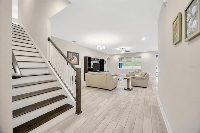 18125 Roseate Dr, Lutz, FL 33558 - living room featuring stairs, a chandelier, recessed lighting, ceiling fan, and light wood-style floors