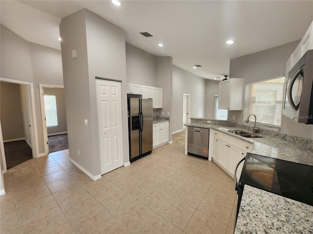 3407 E Comanche Ave, Tampa, FL 33610 - kitchen featuring appliances with stainless steel finishes, light tile patterned flooring, white cabinets, light stone counters, and recessed lighting