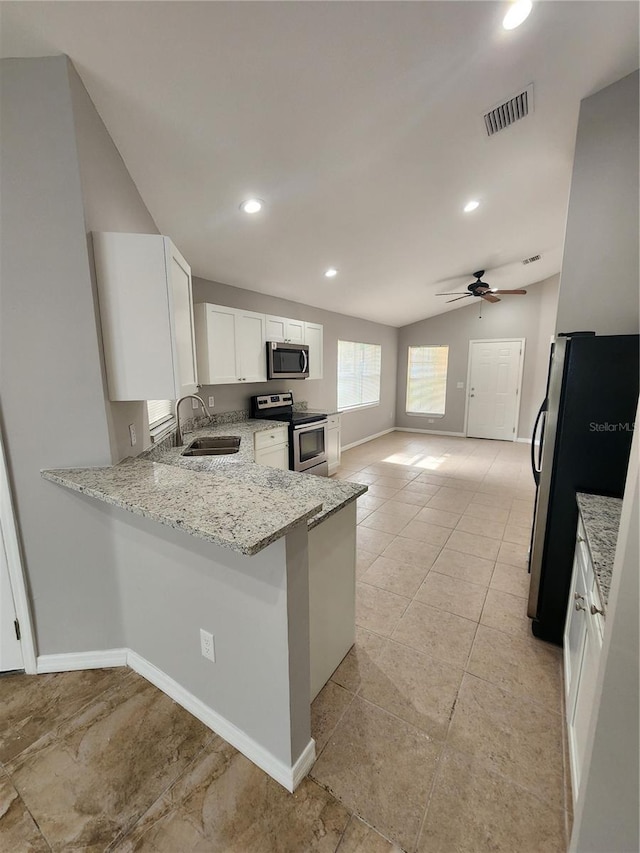 3407 E Comanche Ave, Tampa, FL 33610 - kitchen with appliances with stainless steel finishes, light stone countertops, a peninsula, white cabinets, and lofted ceiling
