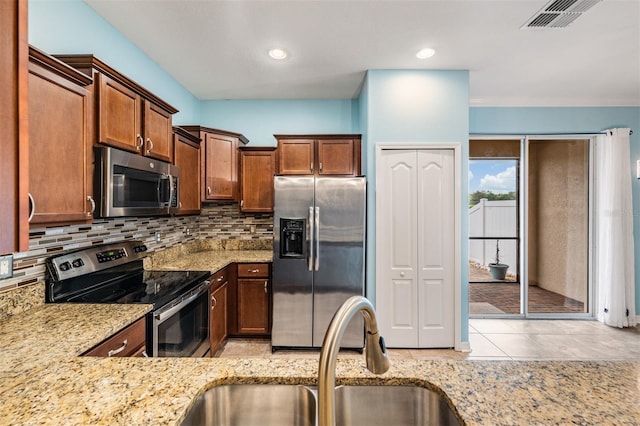 12039 Greengate Dr, Hudson, FL 34669 - kitchen featuring stainless steel appliances, light stone countertops, decorative backsplash, light tile patterned floors, and recessed lighting